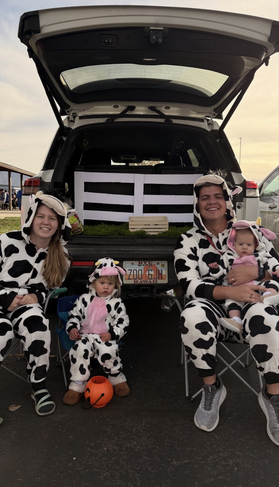 Family in cow costumes at trunk-or-treat